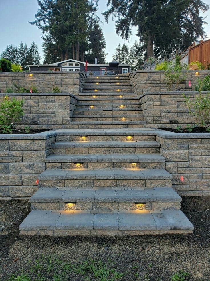 Segmental block retaining walls with integrated stairs and step lighting